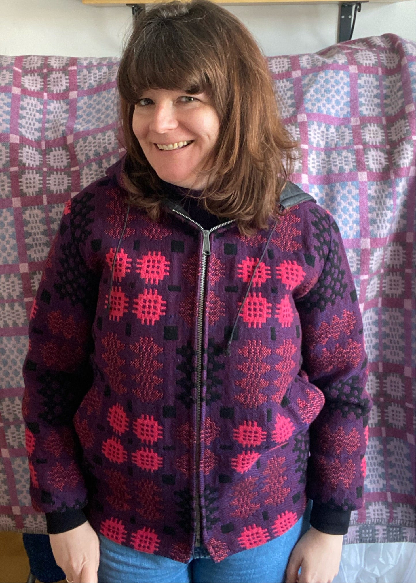 Woman in Welsh Tapestry bomber jacket zip up front in pink and purple print